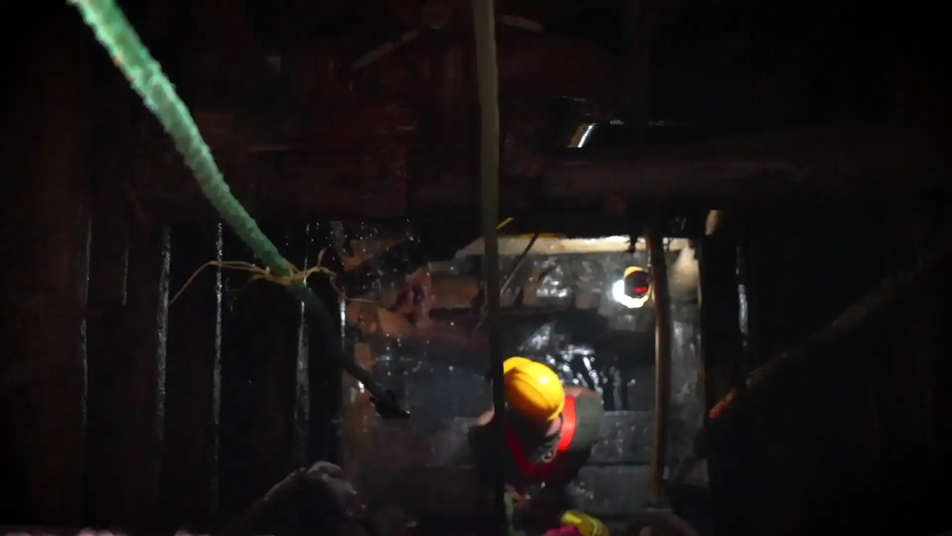 A miner works inside a dimly lit, traditional gem mine.