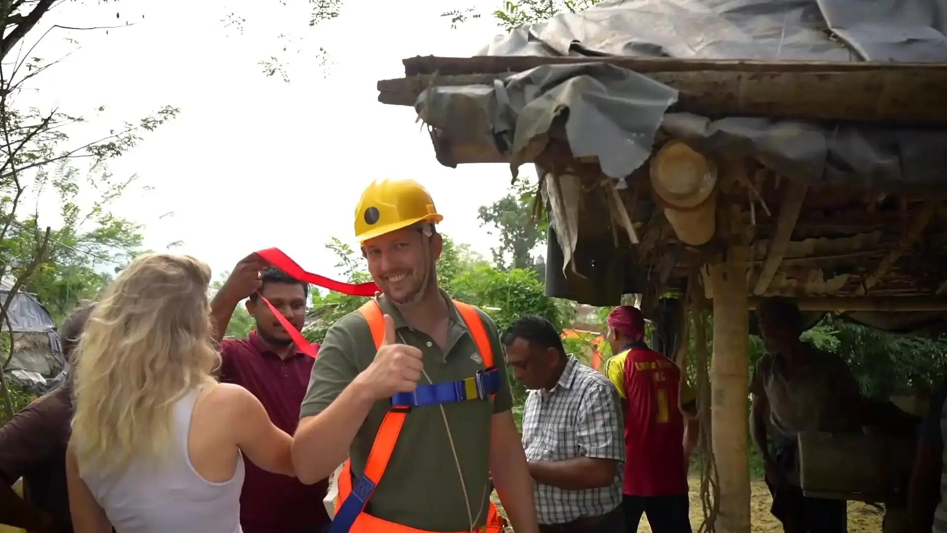 A tourist gives a thumbs-up while wearing a hard hat.